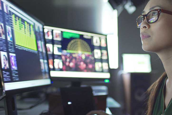 Service desk employee monitors screens