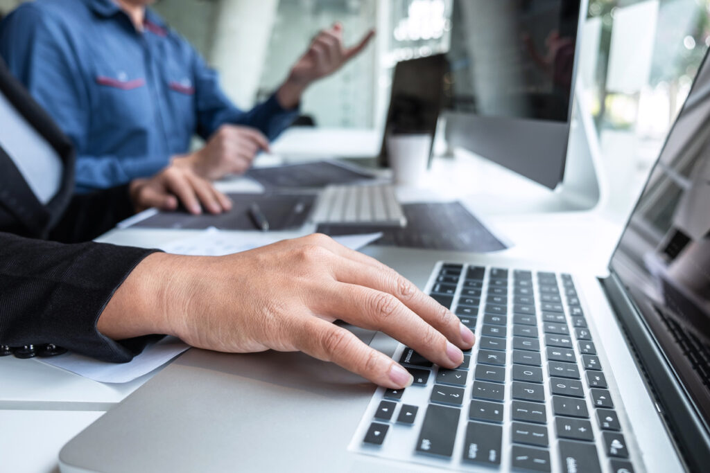 Two people typing on laptops